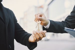 Property management handing keys to the agent